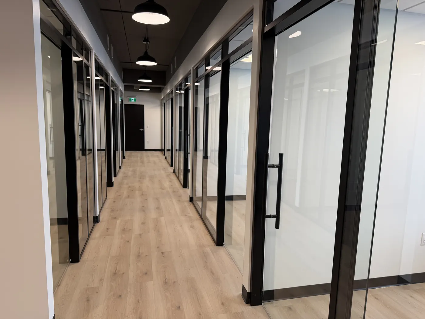 Finished commercial corridor with glass office fronts